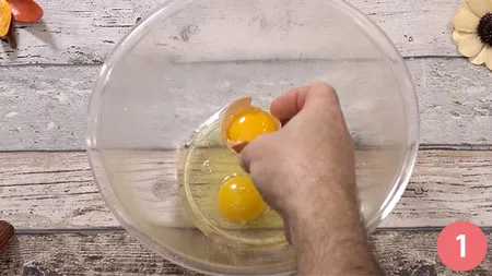 rompere due uova e un tuorlo in una boule