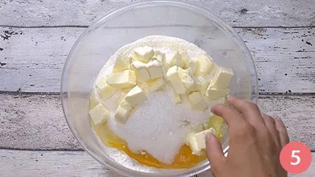 In un recipiente uniamo la farina, l'uovo, lo zucchero, il lievito ed il burro a temperatura ambiente